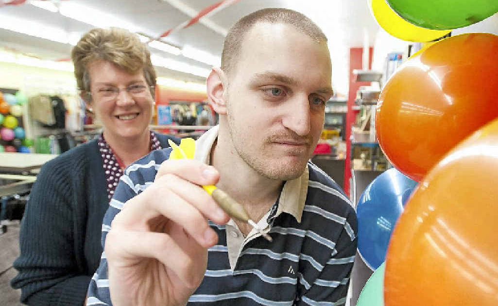 Coffs Harbour Red Cross store manager Deb Southgate gives Todd Bate a shot at a prize celebrating the store’s first birthday. Coffs Harbour Red Cross store manager Deb Southgate gives Todd Bate a shot at a prize celebrating the store’s first birthday.
