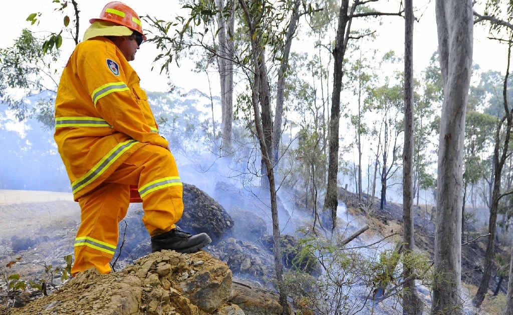 A Rural Fire Service volunteer watches over burning bushland just off the Old Glen Innes Rd. A Rural Fire Service volunteer watches over burning bushland just off the Old Glen Innes Rd.