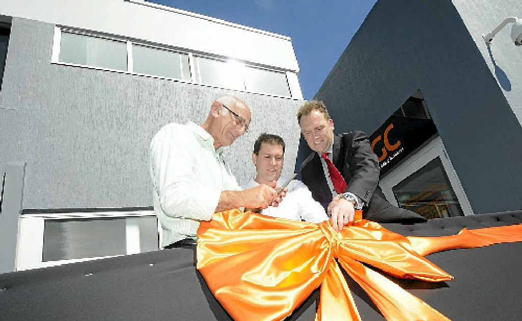 At the official opening of the QGC office, Ren Lanzon, Matt Burnett and Peter Thompson prepare to cut the ribbon. At the official opening of the QGC office, Ren Lanzon, Matt Burnett and Peter Thompson prepare to cut the ribbon.
