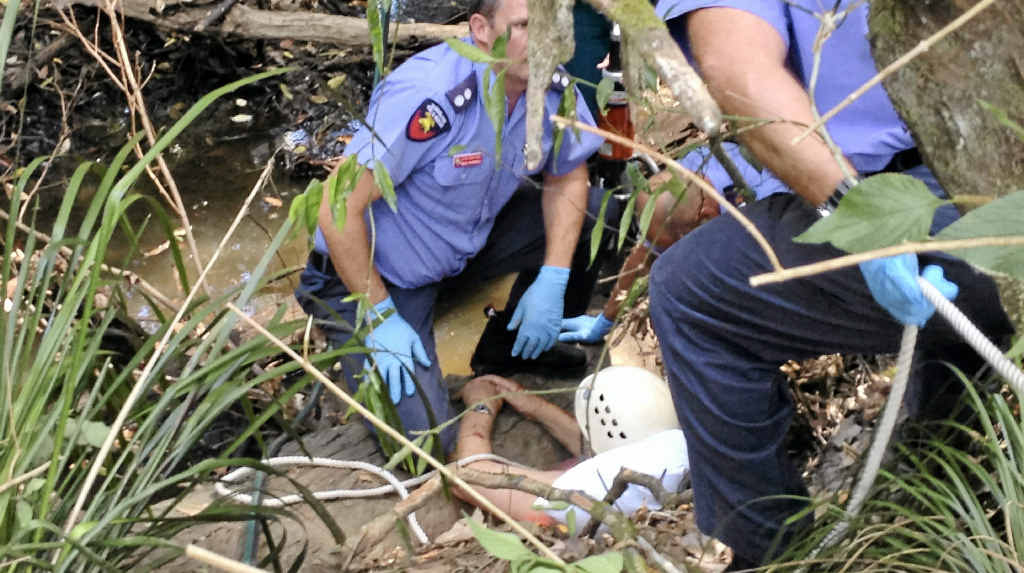 Paramedics and firefighters work to free an elderly man who was trapped in Mountain Creek after trying to rescue his dog. Paramedics and firefighters work to free an elderly man who was trapped in Mountain Creek after trying to rescue his dog.