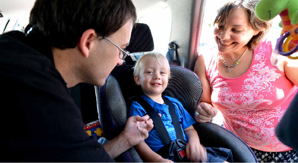 SAFE AND SECURE: Kidsafe Child restraint officer Lachlan Logan checks the car seat of Nathan Salter with his mum Christina D’Amato to ensure it is safely and properly fitted.