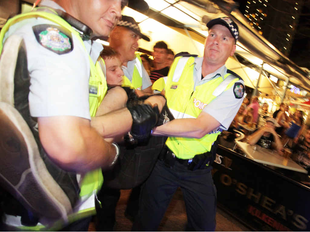 Police take a young person into custody during Schoolies on the Gold Coast. Police take a young person into custody during Schoolies on the Gold Coast.