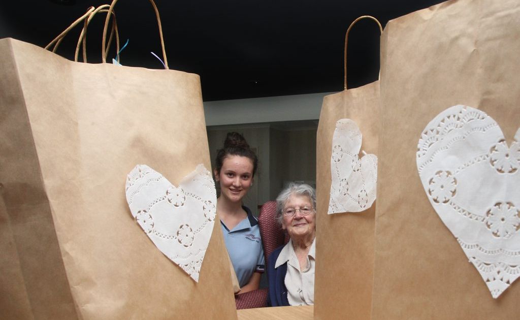 Jemimah Fortune gives 93-year-old Millie Newman a care pack. Photo: Blainey Woodham / Daily News