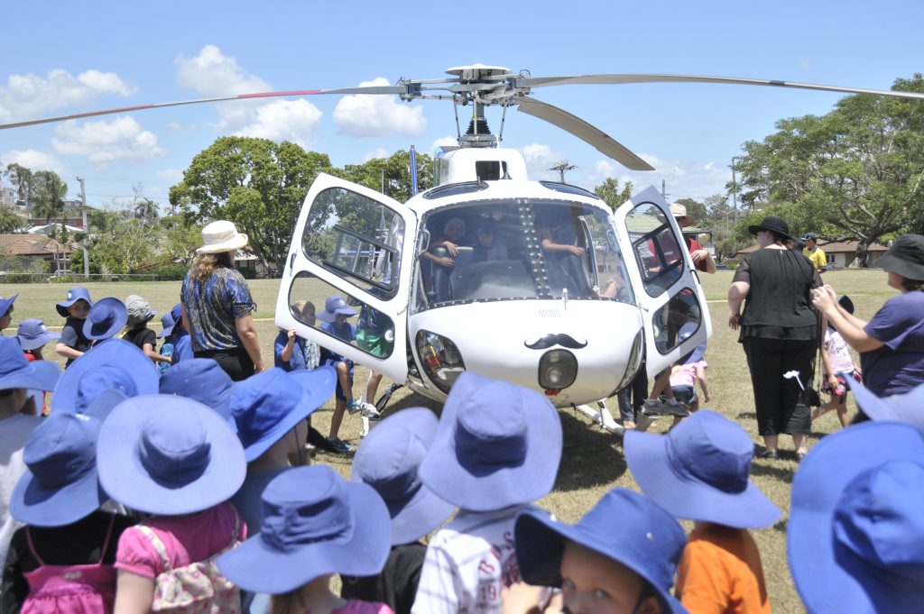 A moustache-wearing helicopter lands at Gladstone West State School to help celebrate Movember. A moustache-wearing helicopter lands at Gladstone West State School to help celebrate Movember.
