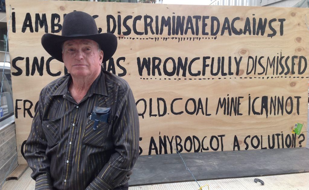 The sign told peak-hour city motorists he was protesting against the coal giant and Blackwater Mine owner over his unfair dismissal four years ago. The sign told peak-hour city motorists he was protesting against the coal giant and Blackwater Mine owner over his unfair dismissal four years ago.