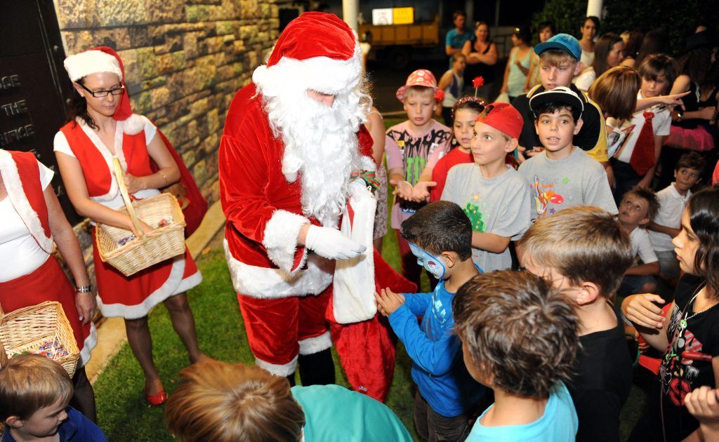 FULL SCHEDULE: Santa keeps himself occupied training his reindeer, overseeing his elves' toy making and appearing at festive functions and events such as this one where he is giving children some treats. FULL SCHEDULE: Santa keeps himself occupied training his reindeer, overseeing his elves' toy making and appearing at festive functions and events such as this one where he is giving children some treats.