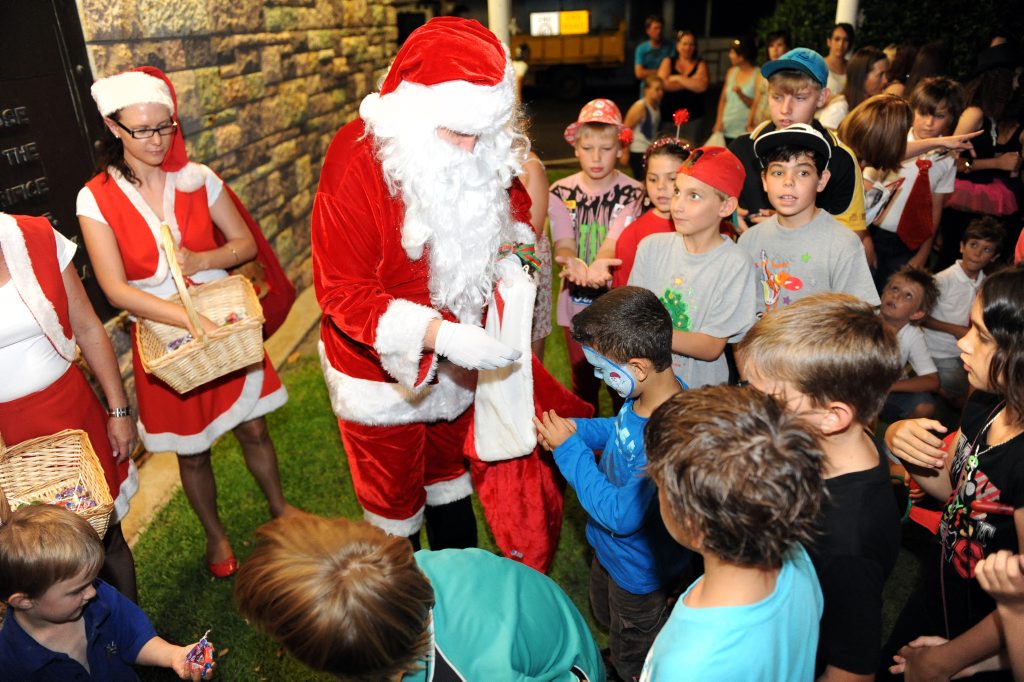 FULL SCHEDULE: Santa keeps himself occupied training his reindeer, overseeing his elves' toy making and appearing at festive functions and events such as this one where he is giving children some treats. FULL SCHEDULE: Santa keeps himself occupied training his reindeer, overseeing his elves' toy making and appearing at festive functions and events such as this one where he is giving children some treats.