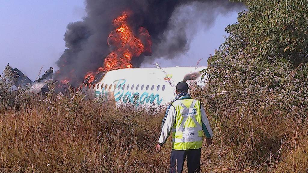 This photo taken on December 25, 2012 shows a man walking the fuselage of an Air Bagan passenger plane burn after it crashed near Heho airport in Myanmar's eastern Shan state. The Myanmar ageing Fokker-100 plane carrying 65 passengers including foreign tourists crash-landed in eastern Shan state, leaving two people dead and 11 others injured, the airline and officials said. AFP PHOTO This photo taken on December 25, 2012 shows a man walking the fuselage of an Air Bagan passenger plane burn after it crashed near Heho airport in Myanmar's eastern Shan state. The Myanmar ageing Fokker-100 plane carrying 65 passengers including foreign tourists crash-landed in eastern Shan state, leaving two people dead and 11 others injured, the airline and officials said. AFP PHOTO