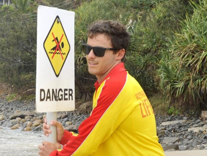 Tom Burns, Byron Bay lifeguard, putting up a sign yesterday warning people not to go swimming after multiple shark sightings. Photo Mireille Merlet-Shaw / The Northern Star Tom Burns, Byron Bay lifeguard, putting up a sign yesterday warning people not to go swimming after multiple shark sightings. Photo Mireille Merlet-Shaw / The Northern Star
