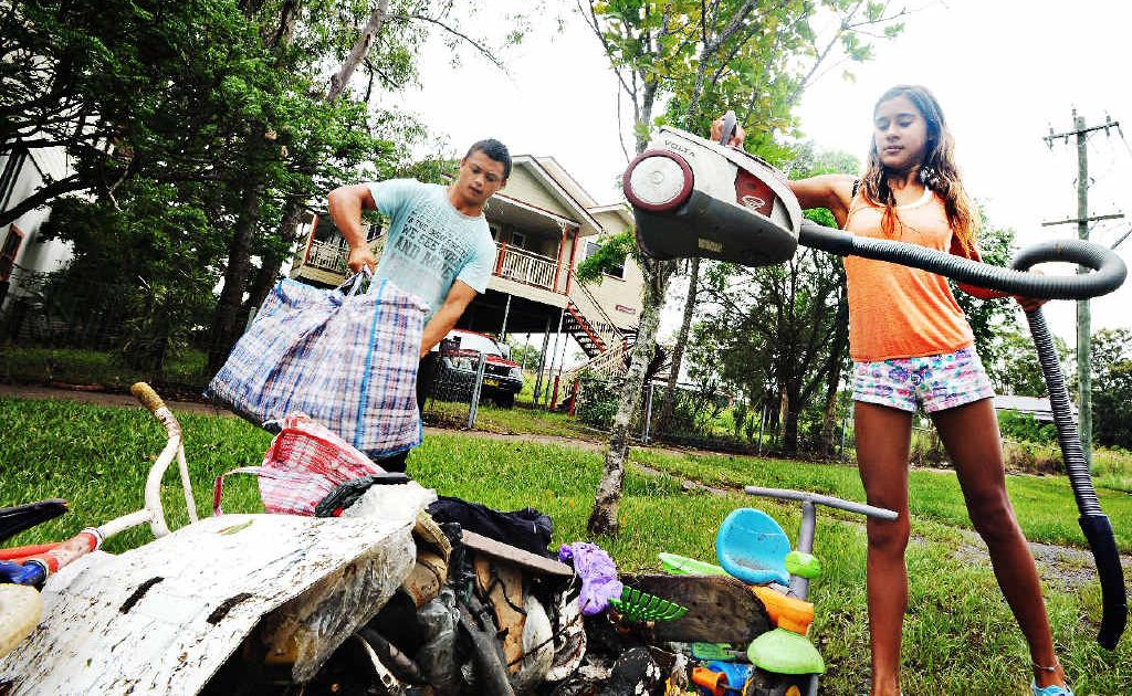 Phyllis Billin (13), of North Lismore, with Aaron Albario (16) cleans out the underneath of her house after floodwaters receded. Phyllis Billin (13), of North Lismore, with Aaron Albario (16) cleans out the underneath of her house after floodwaters receded.