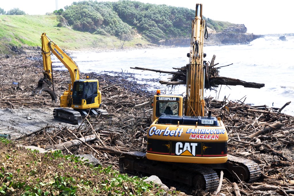 Heavy machinery swings into action removing debris from Yamba's beaches at the weekend. Heavy machinery swings into action removing debris from Yamba's beaches at the weekend.