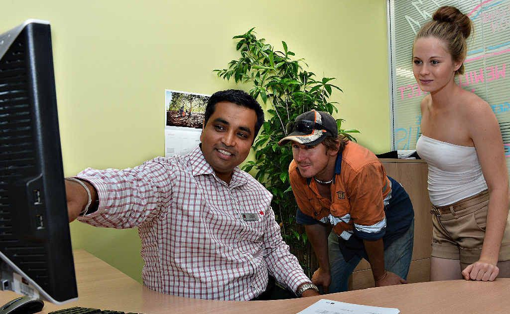 Mackay NAB store manager Younes Chopra talks dollars with Clint Paull and his cousin Vanessa Shelley. Mackay NAB store manager Younes Chopra talks dollars with Clint Paull and his cousin Vanessa Shelley.