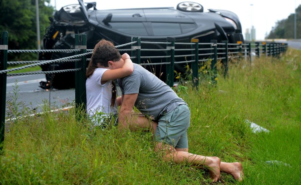 A young couple comfort each other after their car crashed on the M1 motorway. A young couple comfort each other after their car crashed on the M1 motorway.