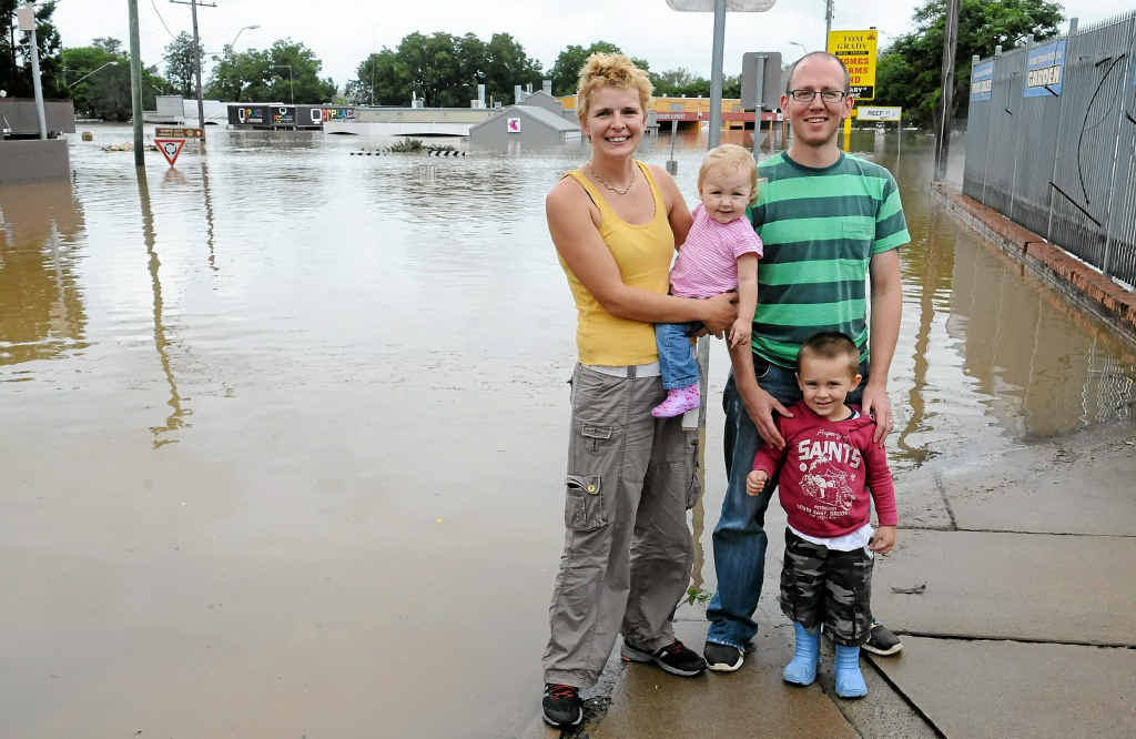 Gemma and Nick Green of PC Place, with their children Evie and Sidney, watch from a distance as the flood falls below the ceiling of their business premises on River Rd. Gemma and Nick Green of PC Place, with their children Evie and Sidney, watch from a distance as the flood falls below the ceiling of their business premises on River Rd.