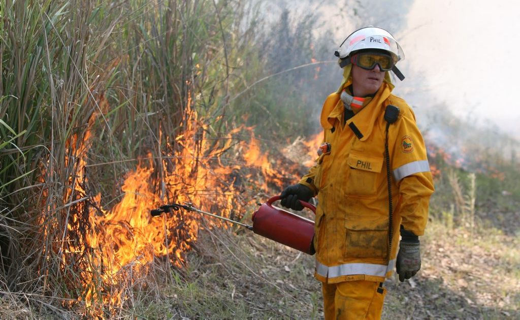 A firefighter from the Cawarral Rural Fire Brigade back burns into a large fast moving bushfire near Mount Charmers. A firefighter from the Cawarral Rural Fire Brigade back burns into a large fast moving bushfire near Mount Charmers.