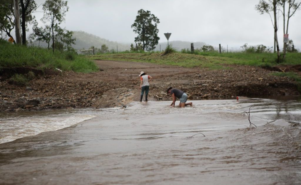 A man checks the depth of a hole on a causeway near Upper Ulam. Photo Allan Reinikka / The Morning Bulletin A man checks the depth of a hole on a causeway near Upper Ulam. Photo Allan Reinikka / The Morning Bulletin