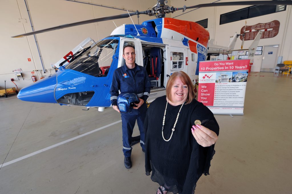 Investment group Think Money's company director, Chris Childs, promotes the Money and Property Expo where donations raised will go to the AGL Action Rescue helicopter, seen with crew member Dan King.
