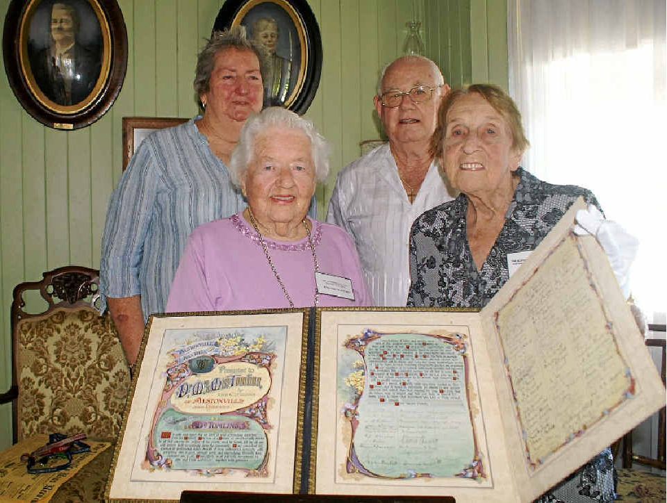 FOND FAREWELL: Displaying Dr W H Tomlins’ gift when he left Alstonville are descendants of people who signed it, Dorothy Crawford and Daphne Noble (front), and Alison Draper and Les Daley. The farewell gift forms part of a display at Crawford House Museum.