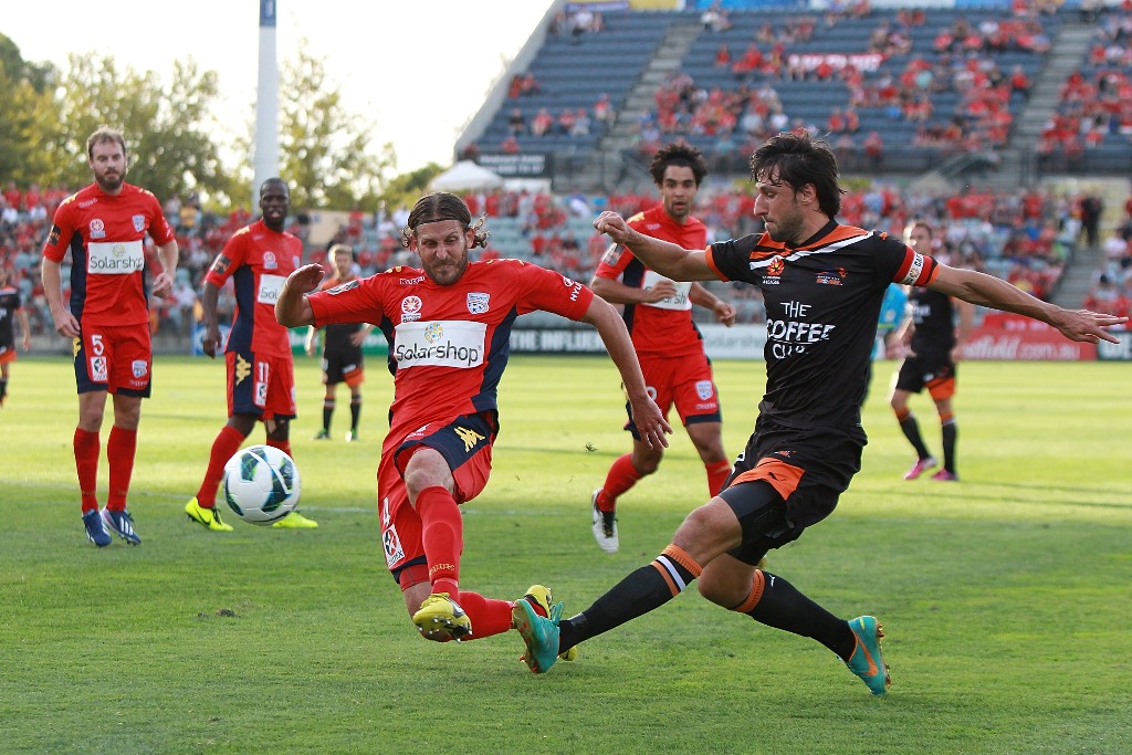 Thomas Broich of Brisbane crosses the ball under pressure from Jonathan McKain of Adelaide during the A-League Elimination Final between Adelaide United and Brisbane Roar at Hindmarsh Stadium on April 7, 2013 in Adelaide, Australia. Thomas Broich of Brisbane crosses the ball under pressure from Jonathan McKain of Adelaide during the A-League Elimination Final between Adelaide United and Brisbane Roar at Hindmarsh Stadium on April 7, 2013 in Adelaide, Australia.