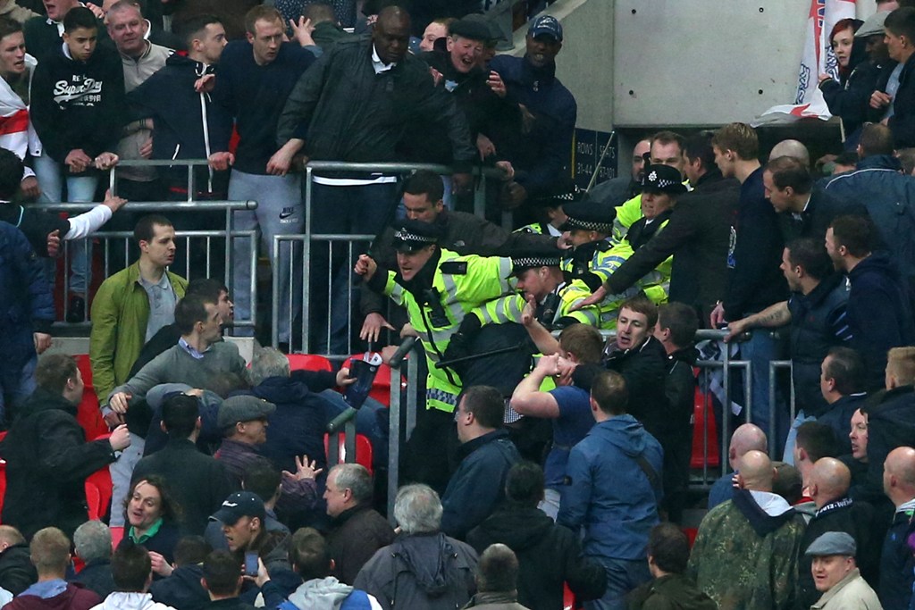 Police officers wield batons as they attempt to stop Millwall supporters fighting amongst themselves during the FA Cup with Budweiser Semi Final match between Millwall and Wigan Athletic at Wembley Stadium on April 13, 2013 in London, England. Police officers wield batons as they attempt to stop Millwall supporters fighting amongst themselves during the FA Cup with Budweiser Semi Final match between Millwall and Wigan Athletic at Wembley Stadium on April 13, 2013 in London, England.
