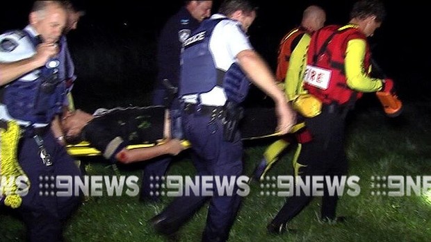 Police and emergency services crews carry the injured man. Police and emergency services crews carry the injured man.