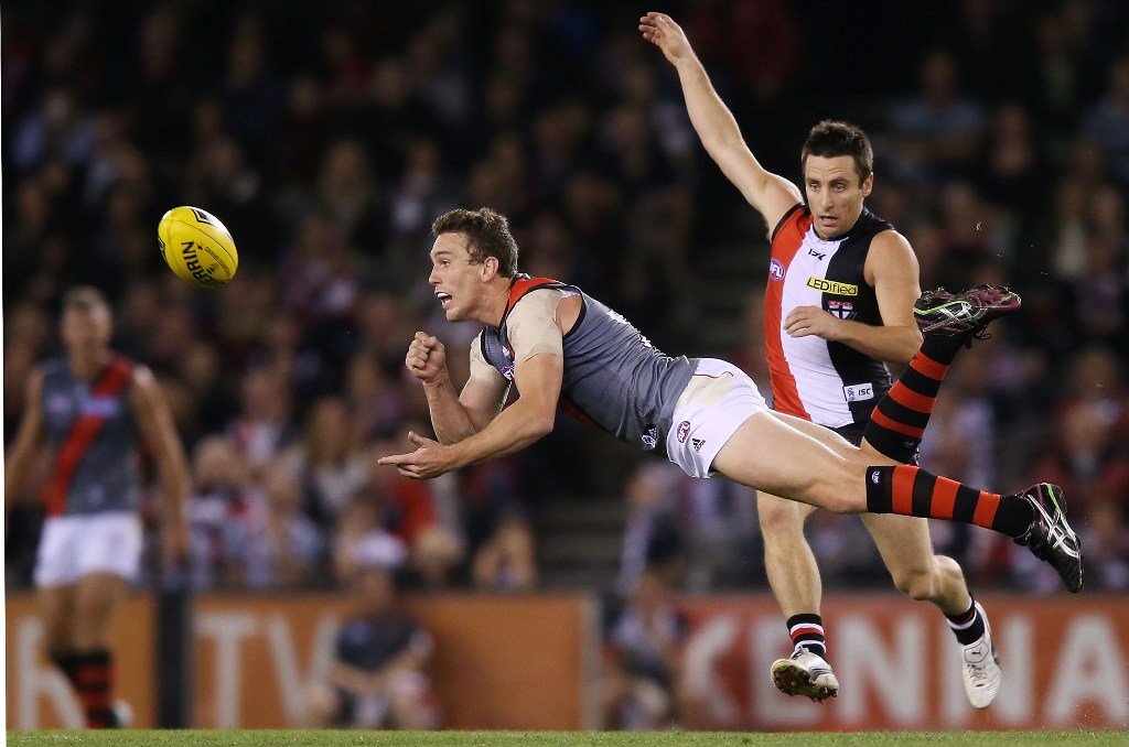 Heath Hocking of the Bombers handpasses the ball away from Stephen Milne of the Saints during the round four AFL match between the St Kilda Saints and the Essendon Bombers at Etihad Stadium on April 20, 2013 in Melbourne, Australia. Heath Hocking of the Bombers handpasses the ball away from Stephen Milne of the Saints during the round four AFL match between the St Kilda Saints and the Essendon Bombers at Etihad Stadium on April 20, 2013 in Melbourne, Australia.