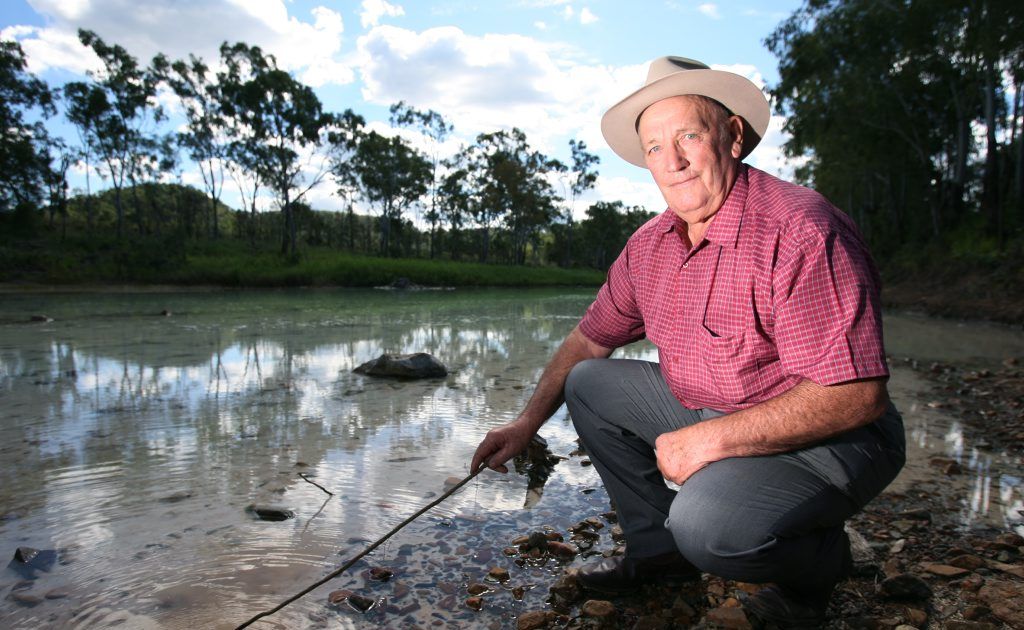 Tom Foster on the Dee River downstream from Mount Morgan where a 1 cm deposit of white material has settled on the riverbed. Photo: Chris Ison / The Morning Bulletin Tom Foster on the Dee River downstream from Mount Morgan where a 1 cm deposit of white material has settled on the riverbed. Photo: Chris Ison / The Morning Bulletin