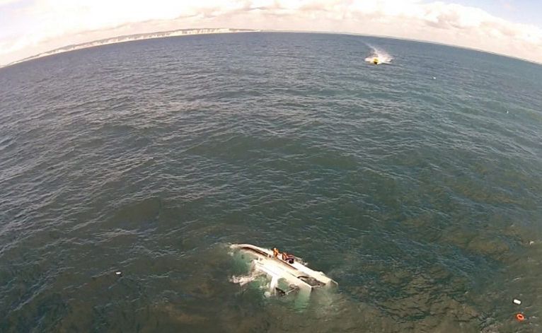 Three men wait to be rescued after their boat capsized near the southern end of Fraser Island. Three men wait to be rescued after their boat capsized near the southern end of Fraser Island.