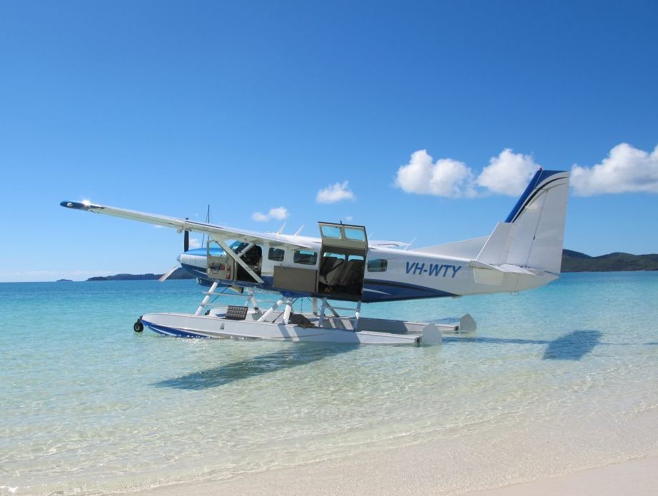 A seaplane lands in turquoise waters at Whitehaven Beach. A seaplane lands in turquoise waters at Whitehaven Beach.
