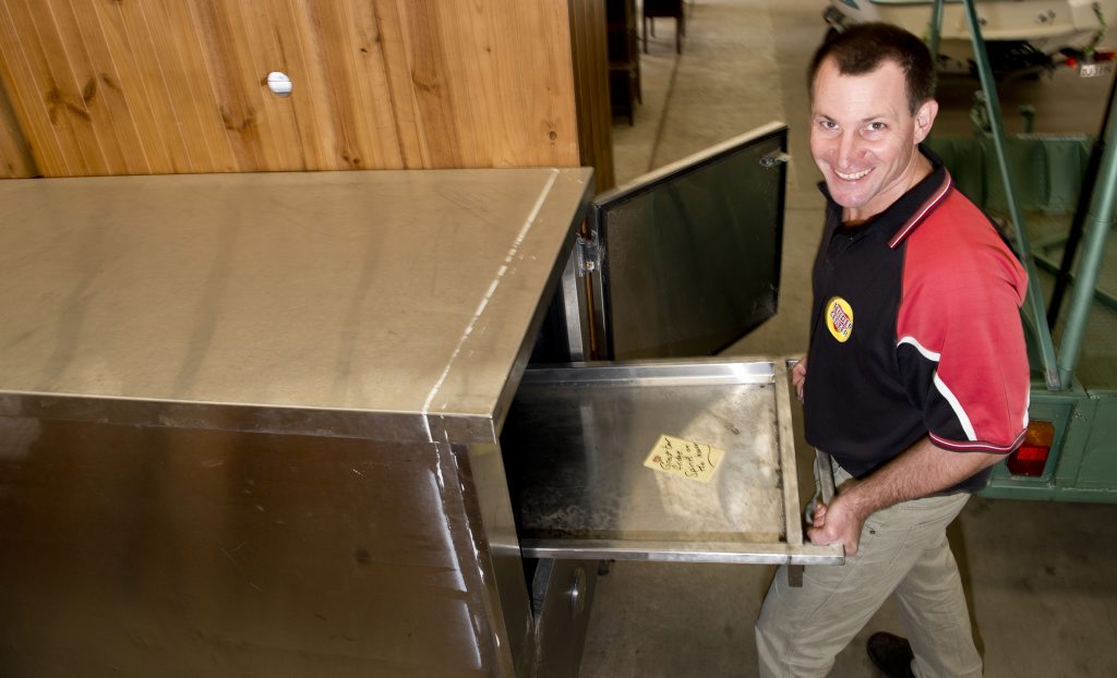 Terry George with a mortuary fridge he sold to a farmer. Terry George with a mortuary fridge he sold to a farmer.