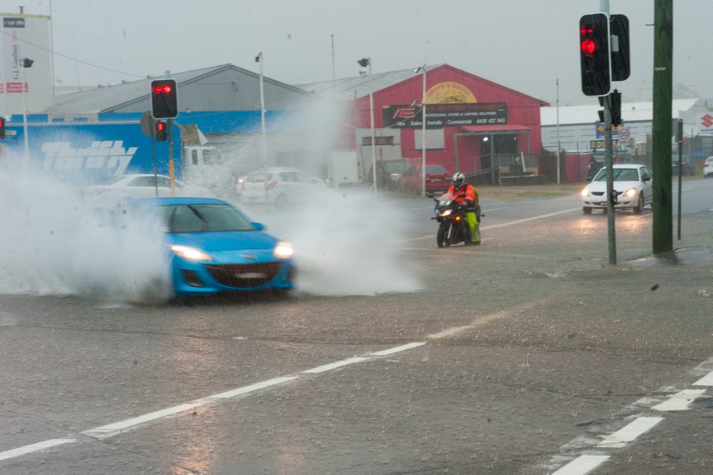 heavy rain hits Coffs harbour. A motor cyclist braces for the back was as a car goes through the Marcia street intersection Photo: Trevor Veale / The Coffs Coast Advocate heavy rain hits Coffs harbour. A motor cyclist braces for the back was as a car goes through the Marcia street intersection Photo: Trevor Veale / The Coffs Coast Advocate