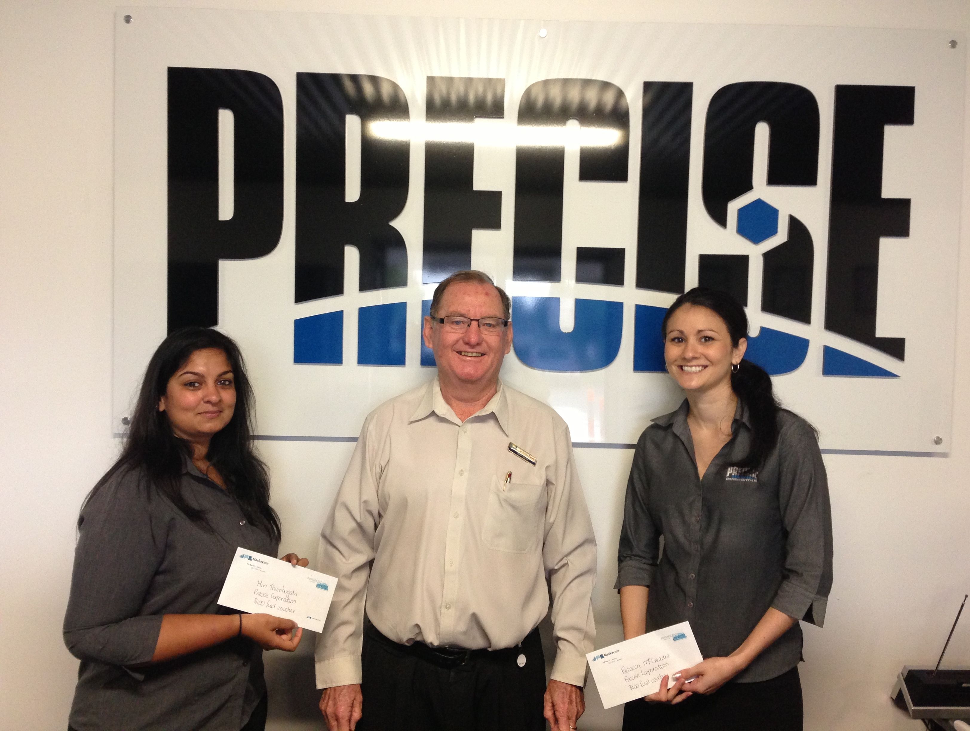 Precise Corporation carpoolers Hiri Thambugala and Danielle O'Brien with Cr Kevin Casey accept the fuel vouchers on behalf of their business.
