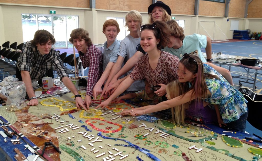 AICM students (from left) Ashley Martin, Rowan White, Jamille Fernandez, James McDonald, Yasmin Morris, Elwood Smith-Cripps (rear with hat) Ben Wight (face obscured) and Amellia Winkley place their glass tiles in Mundubbera’s centenary mural. AICM students (from left) Ashley Martin, Rowan White, Jamille Fernandez, James McDonald, Yasmin Morris, Elwood Smith-Cripps (rear with hat) Ben Wight (face obscured) and Amellia Winkley place their glass tiles in Mundubbera’s centenary mural.