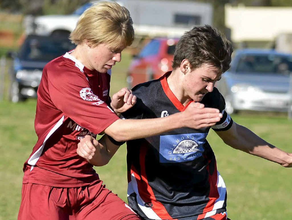 United player Damon Allen and Warwick player Casey Baguley play in the senior game at Queens Park yesterday.