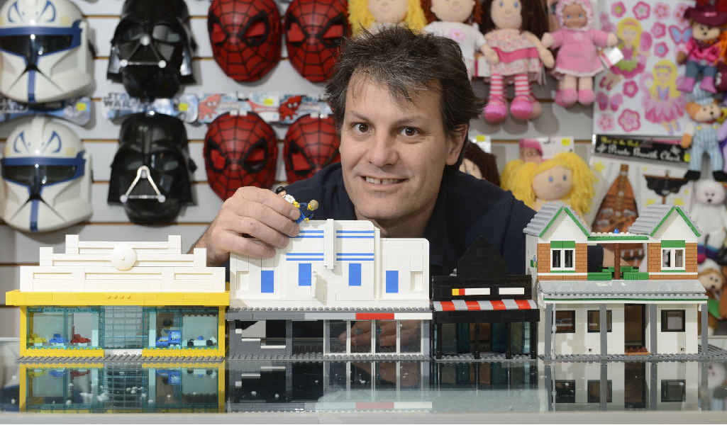 BLOCK AT A TIME: Boyd Moore from Toyworld Maclean with some of the Lego constructions of the main street by Brendan James. Photo: Adam Hourigan BLOCK AT A TIME: Boyd Moore from Toyworld Maclean with some of the Lego constructions of the main street by Brendan James. Photo: Adam Hourigan