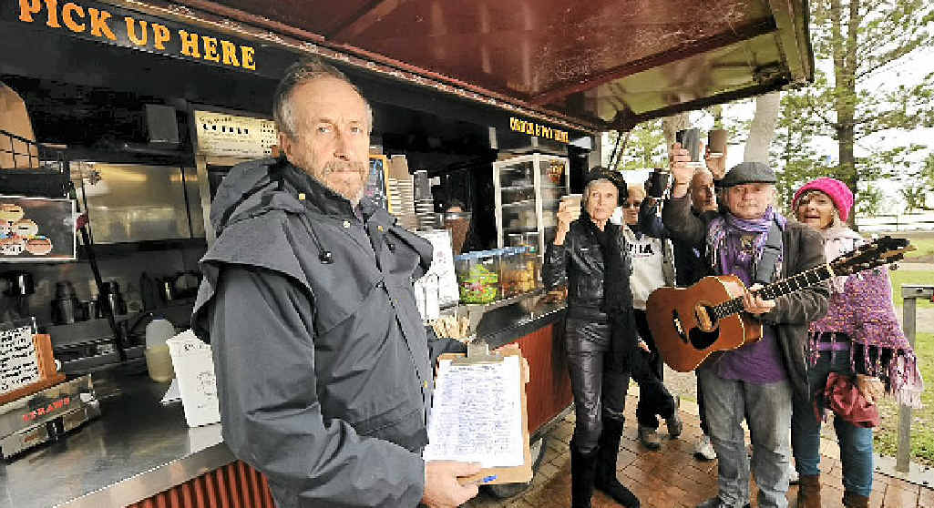 Rob Muston displays his petition against the closure of his coffee van, while supporters gather. Rob Muston displays his petition against the closure of his coffee van, while supporters gather.