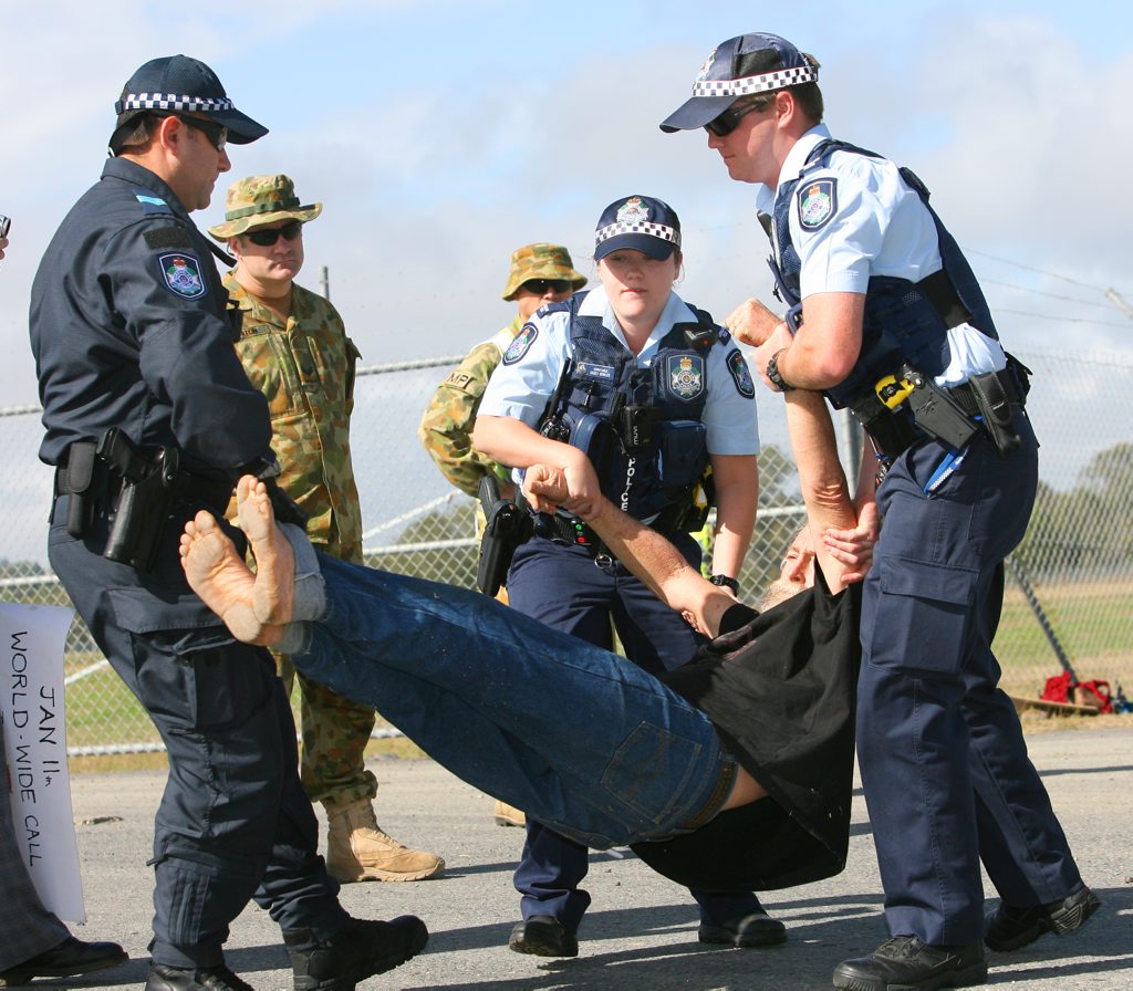 Police move in to arrest Jim Dowling during an anti-war protest outside Camp Rocky during Exercise Talisman Sabre. Photo: Chris Ison / The Morning Bulletin Police move in to arrest Jim Dowling during an anti-war protest outside Camp Rocky during Exercise Talisman Sabre. Photo: Chris Ison / The Morning Bulletin