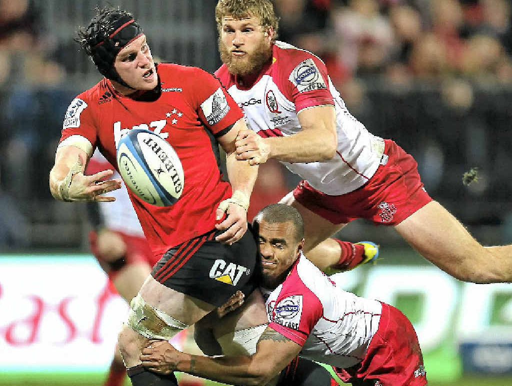 The Crusaders’ Matt Todd offloads in the tackle of the Reds’ Will Genia and Dom Shipperley in last night’s qualifiying final in Christchurch. The Crusaders’ Matt Todd offloads in the tackle of the Reds’ Will Genia and Dom Shipperley in last night’s qualifiying final in Christchurch.