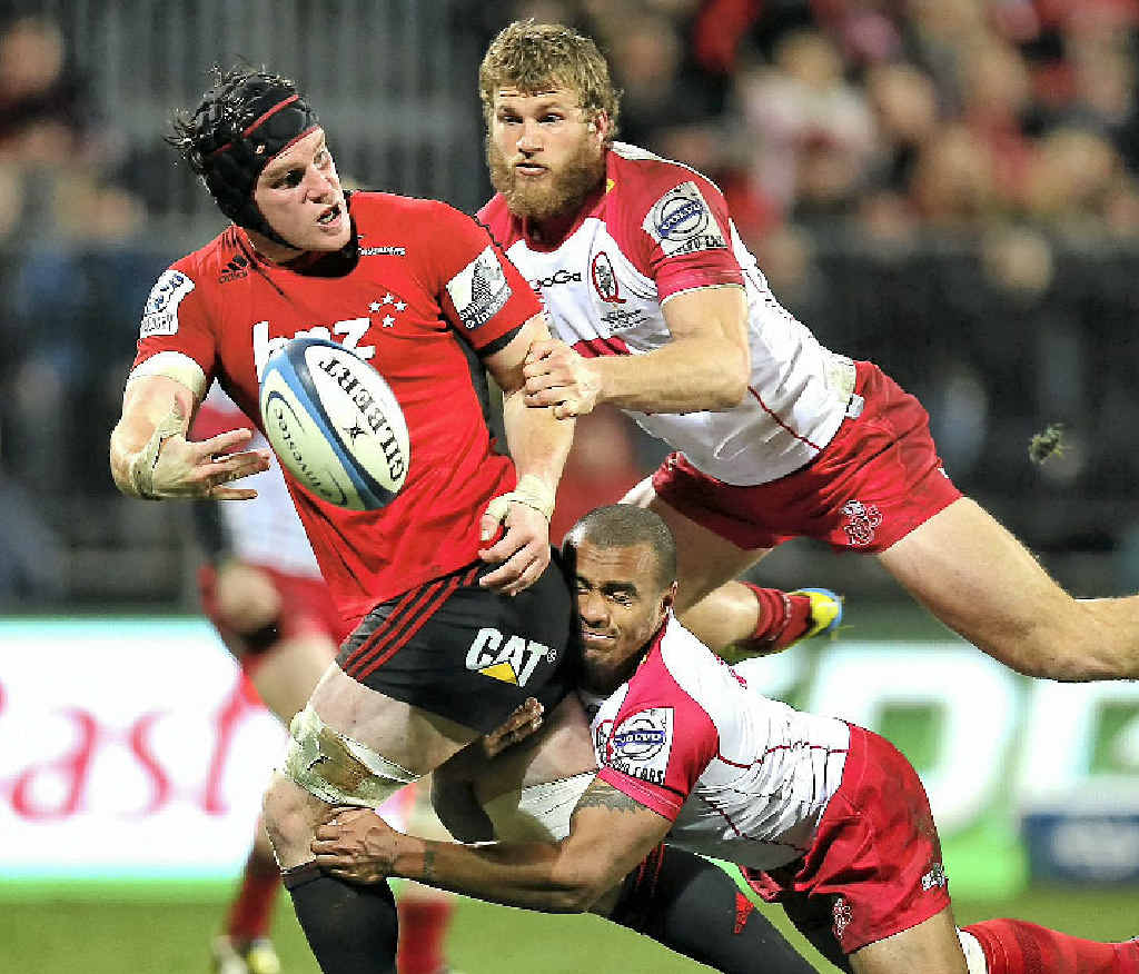 The Crusaders’ Matt Todd offloads in the tackle of the Reds’ Will Genia and Dom Shipperley in last night’s qualifiying final in Christchurch. The Crusaders’ Matt Todd offloads in the tackle of the Reds’ Will Genia and Dom Shipperley in last night’s qualifiying final in Christchurch.