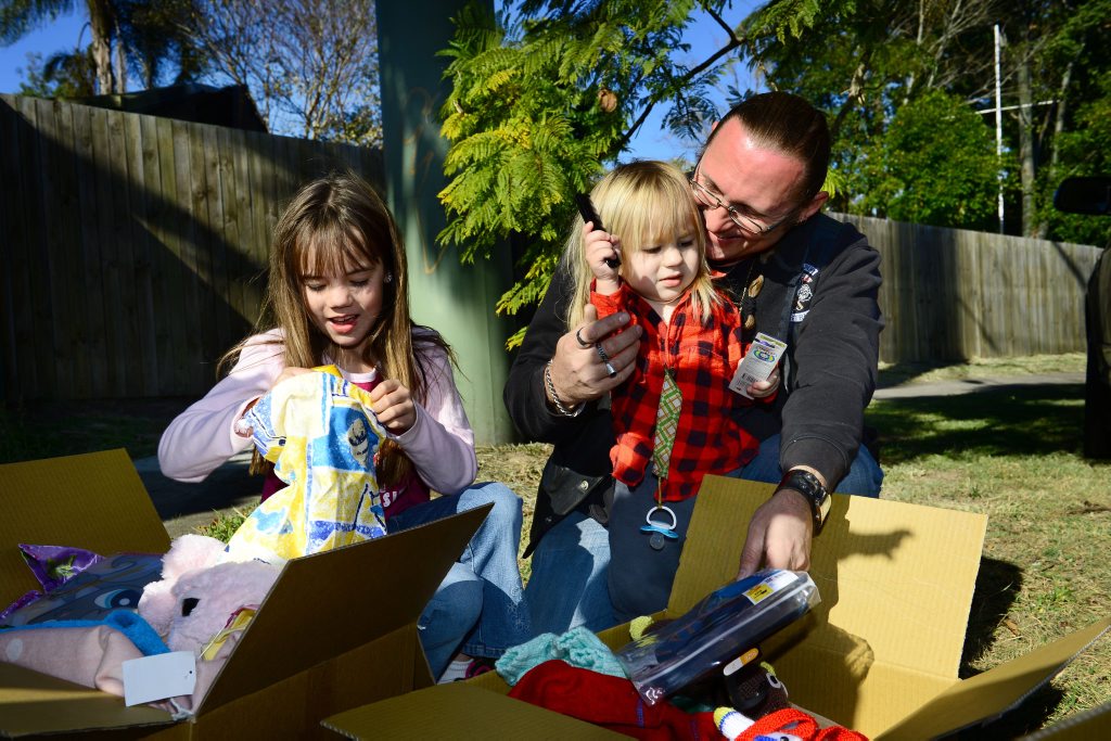 SMILING AGAIN: Tahlia Acai, 8, Xander Hill, 2, and Norman Hill had mixed emotions as they received gifts after losing all their possessions. SMILING AGAIN: Tahlia Acai, 8, Xander Hill, 2, and Norman Hill had mixed emotions as they received gifts after losing all their possessions.