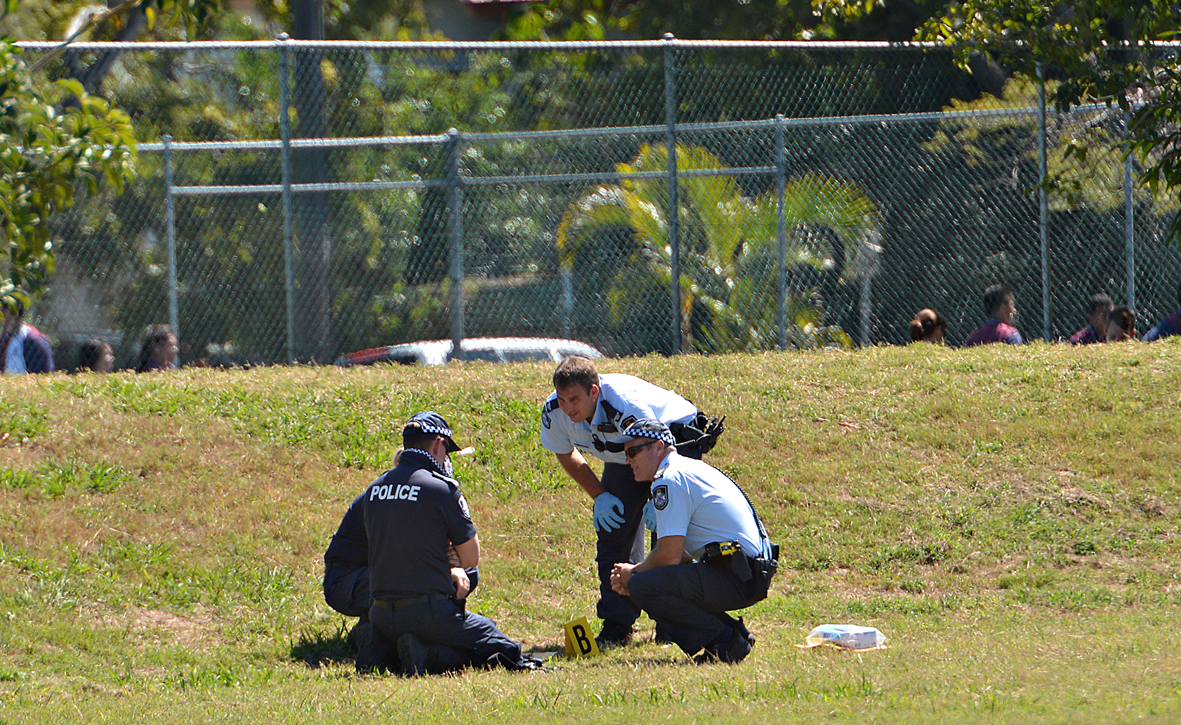 Police inspect on of the home-made bombs on the school oval. Police inspect on of the home-made bombs on the school oval.