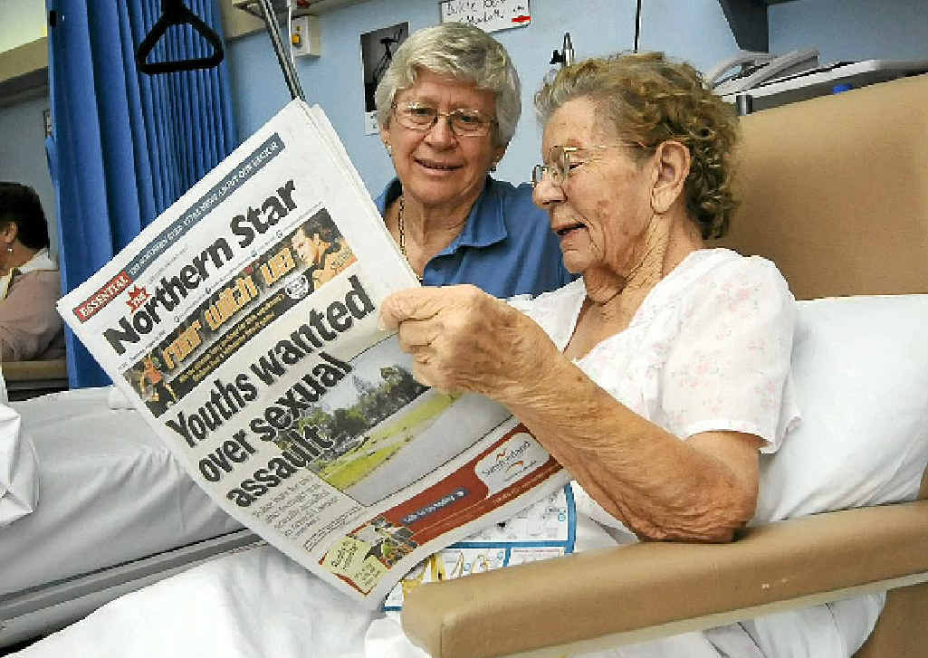 KEEPING UP: Nurse Meryl Bennett looks on as patient Dulcie Box read The Northern Star in her Hospital bed in Casino Hospital. KEEPING UP: Nurse Meryl Bennett looks on as patient Dulcie Box read The Northern Star in her Hospital bed in Casino Hospital.