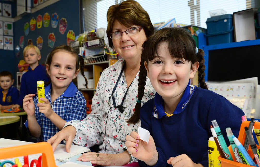 Amberley District State School teacher Christine New uses a Baha, or Bone Anchored Hearing Aid, to help her keep teaching her prep students, including Lily Goulding (left) and Matarna Ashworth. Amberley District State School teacher Christine New uses a Baha, or Bone Anchored Hearing Aid, to help her keep teaching her prep students, including Lily Goulding (left) and Matarna Ashworth.