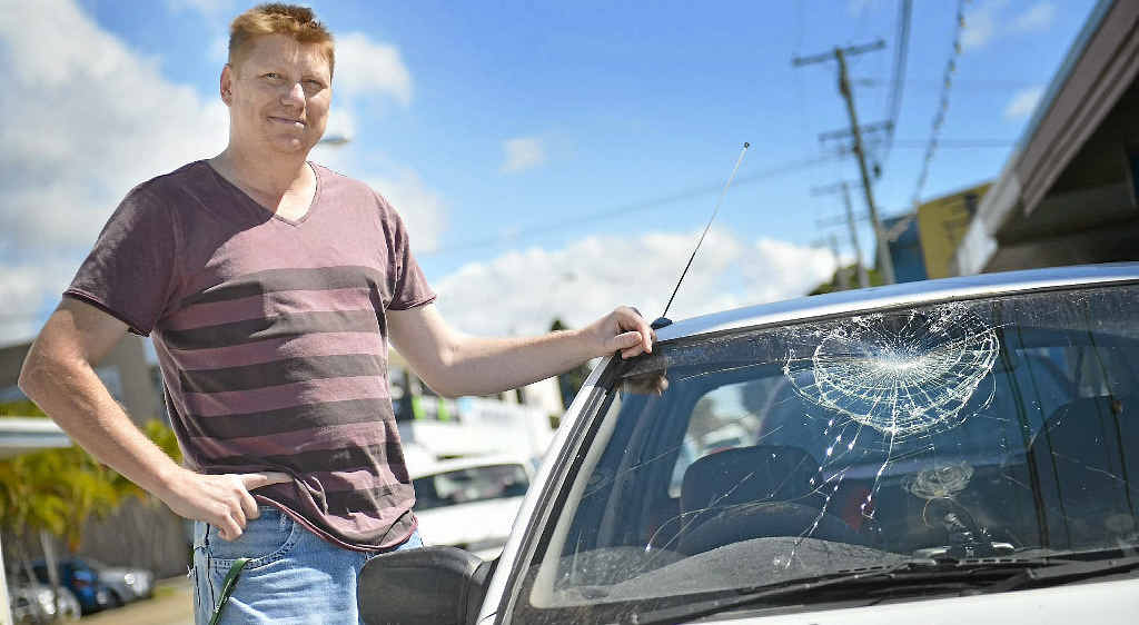 Jarod Foster inspects his car’s damaged windscreen on Tank St in Gladstone. Jarod Foster inspects his car’s damaged windscreen on Tank St in Gladstone.