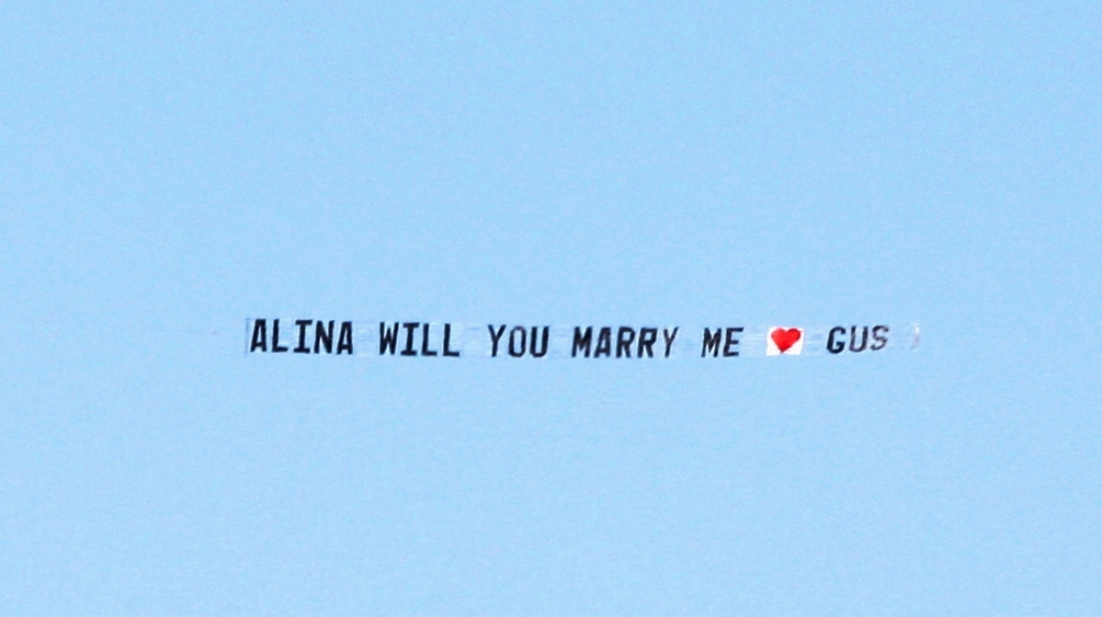 PLANE dragging a sign, “Alina will you marry me, Gus” flew over Point Cartwright. PLANE dragging a sign, “Alina will you marry me, Gus” flew over Point Cartwright.