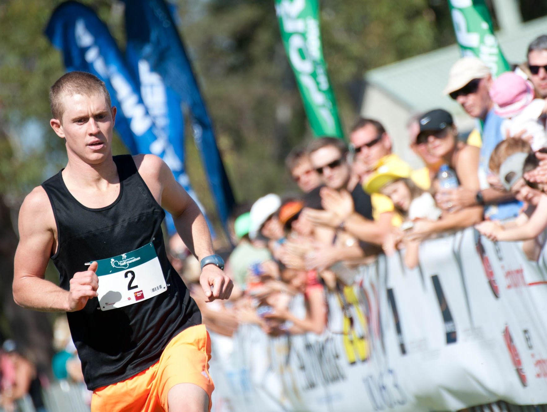 Half Marathon winner Richard Pearson is cheered over the line by a huge gallery of Coffs Coast fans.