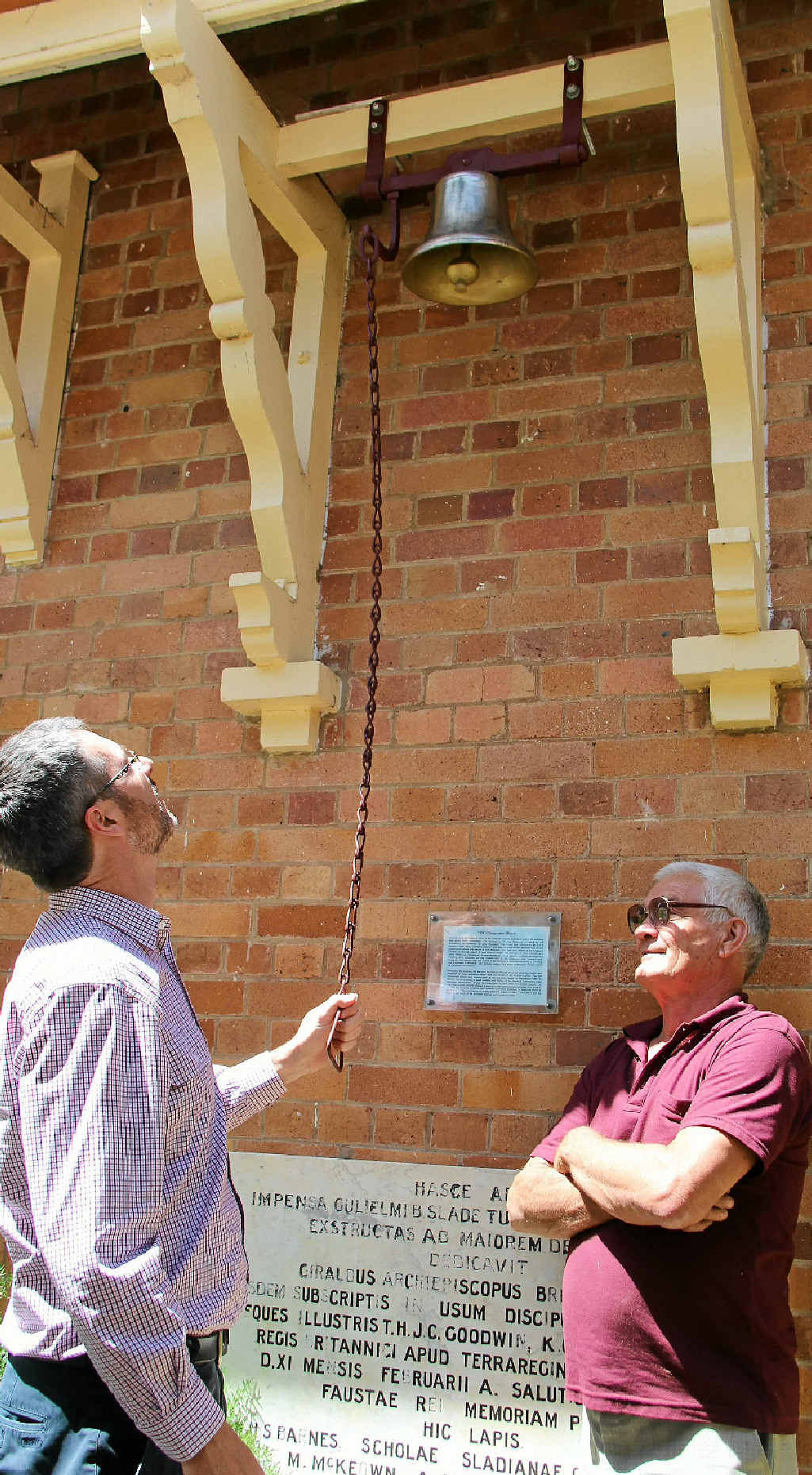 Eddie Pryor watches Warwick Christian College principal Terrance McCorkell try out the returned bell.