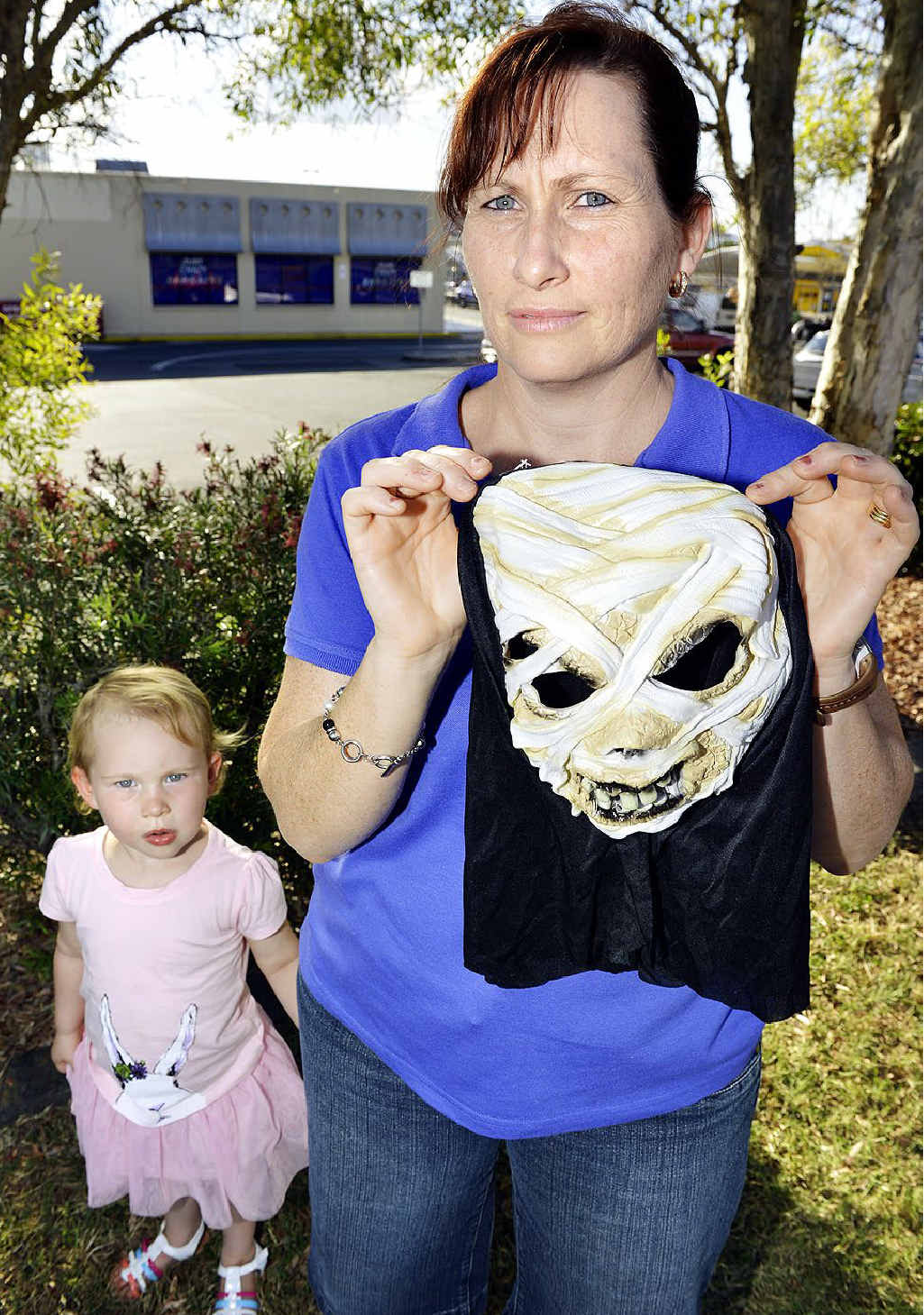 SCARY: Lauren Cochrane holds up a Halloween mask purchased from Just Crazy Bargains in Booval. Mrs Cochrane says the shop’s Halloween display reduced her daughter to tears. SCARY: Lauren Cochrane holds up a Halloween mask purchased from Just Crazy Bargains in Booval. Mrs Cochrane says the shop’s Halloween display reduced her daughter to tears.