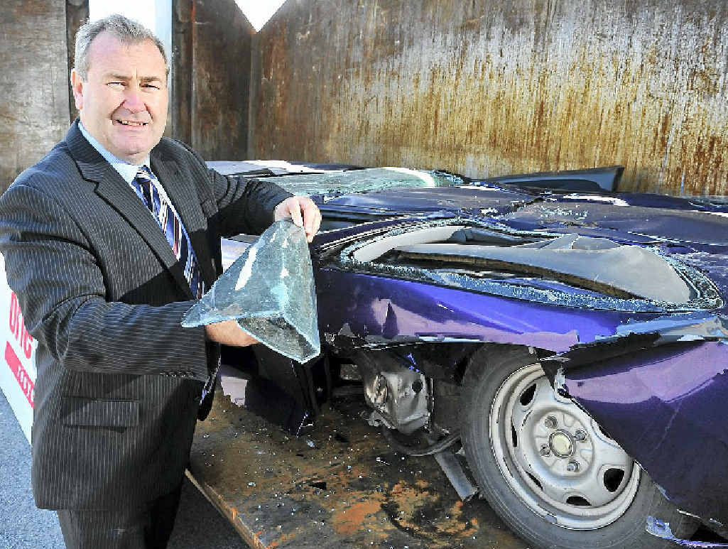 HOONS SQUEEZED: Police Minister Jack Dempsey looks at a crushed vehicle at the announcement of new legislation designed to give Queensland the toughest anti-hooning legislation in the country. HOONS SQUEEZED: Police Minister Jack Dempsey looks at a crushed vehicle at the announcement of new legislation designed to give Queensland the toughest anti-hooning legislation in the country.