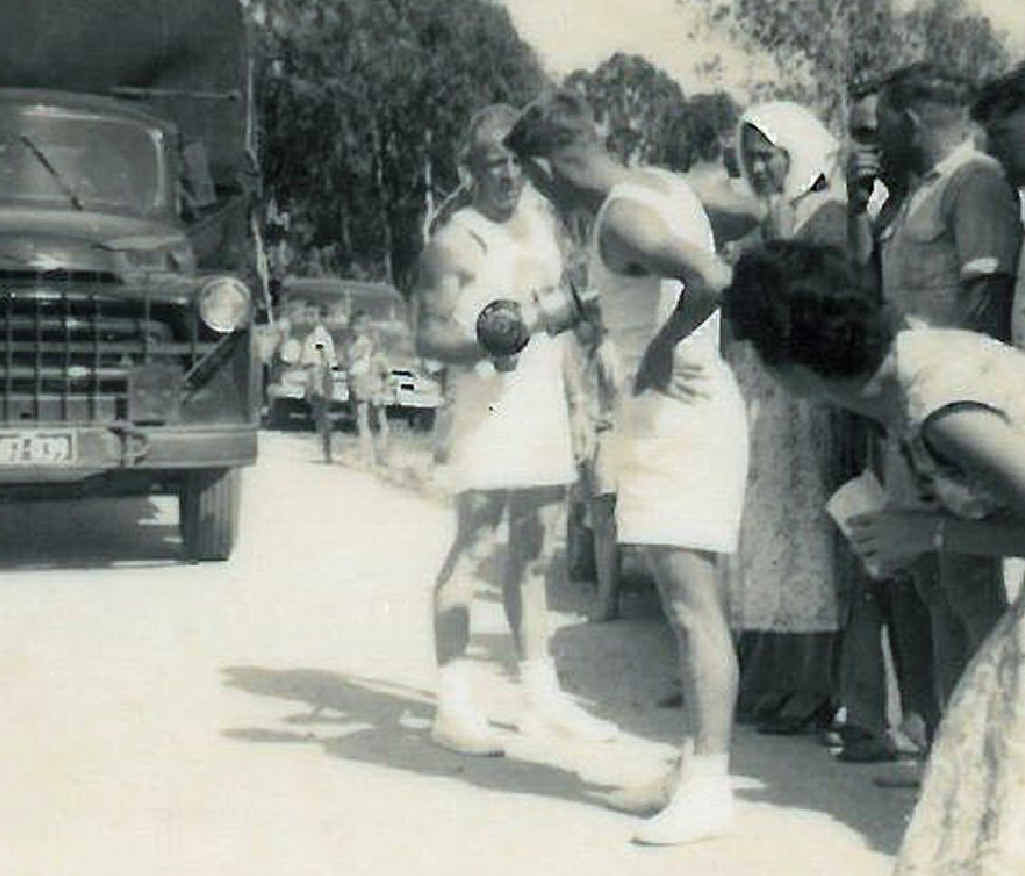 John Rogers (left) transfers the flame to Ernie Hay. John Rogers (left) transfers the flame to Ernie Hay.